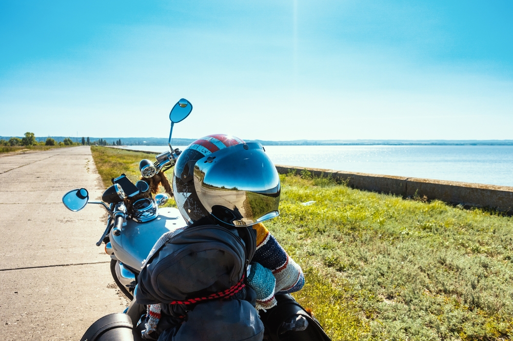 Picture of helmet and motorcycle in front of a body of water
