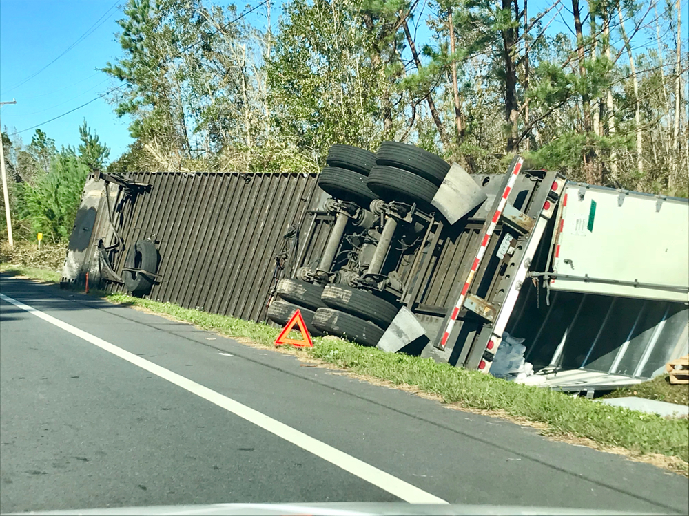 Tipped-over semi truck on median of Florida interstate