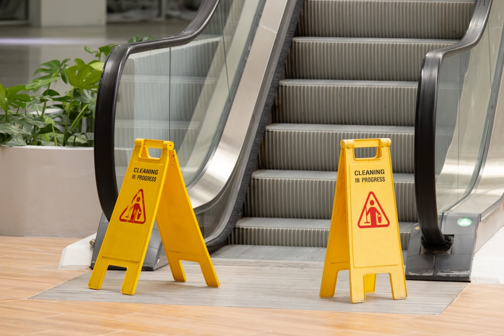 Wet floor standees block an escalator entrance
