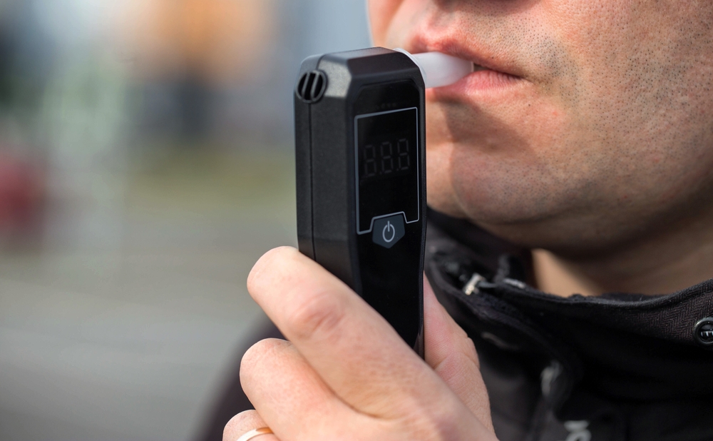 Close-up of man taking a breathalyzer test