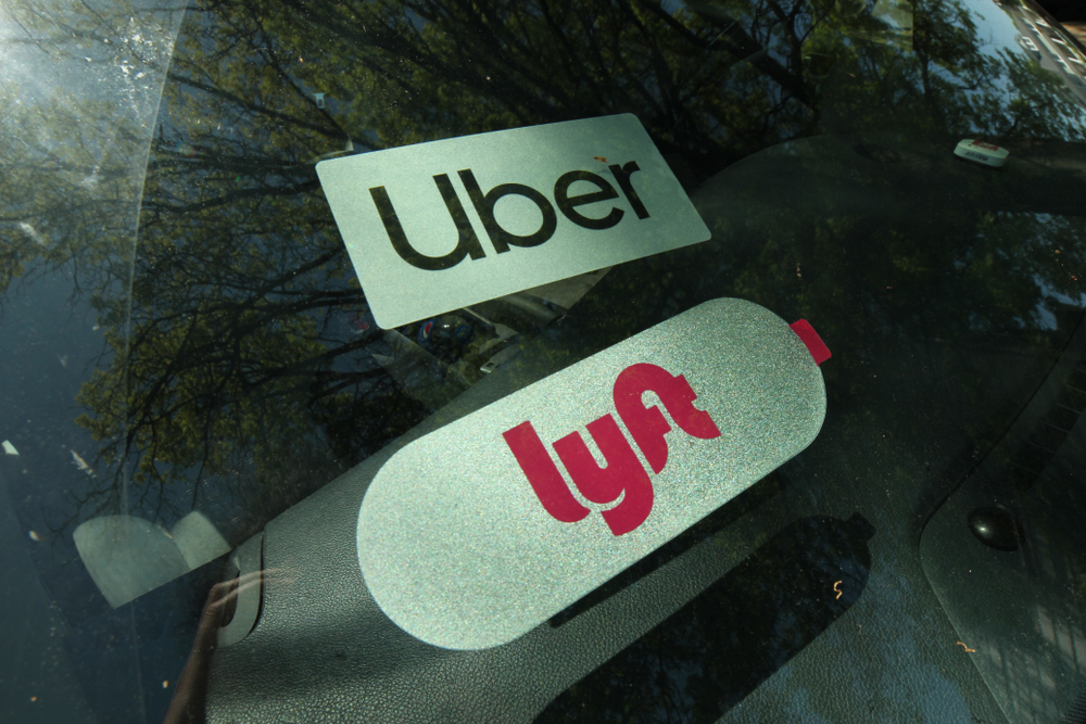 Uber and Lyft rideshare tags displayed in a car window